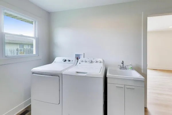 a utility room with a sink dryer and washer