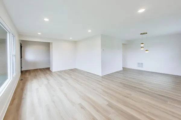 a view of empty room with wooden floor