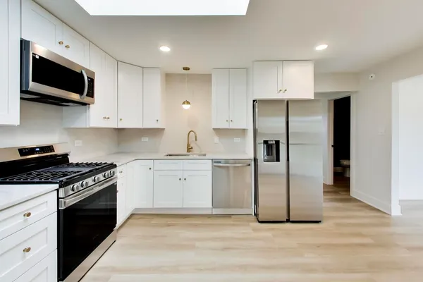 a kitchen with stainless steel appliances granite countertop a stove a refrigerator and a microwave