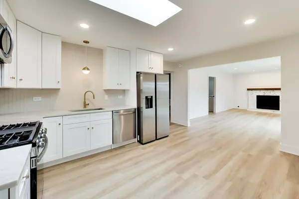 a kitchen with stainless steel appliances a refrigerator sink and white cabinets