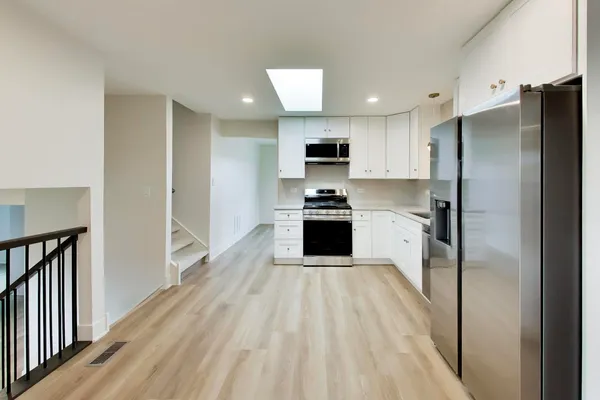 a kitchen with stainless steel appliances a refrigerator sink and microwave
