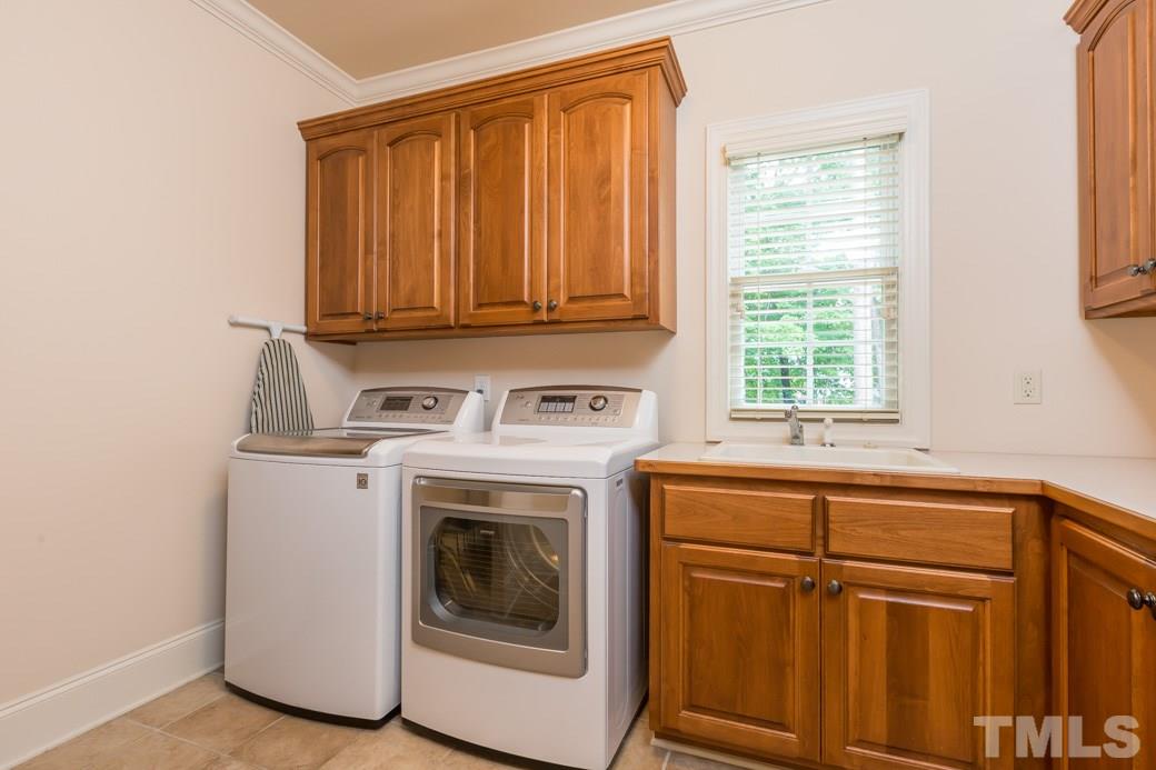 7220 Sunset Glen Point Raleigh, NC 27614 - Photo 22 of 25 Lots of cabinets, sink, counterspace and tiled drain area provide a great space to clean your toughest messes!