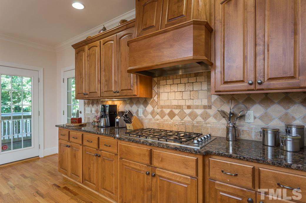 7220 Sunset Glen Point Raleigh, NC 27614 - Photo 6 of 25 Granite countertops, XL island, gas stove top and separate wall oven are just some of the grand features in the kitchen.