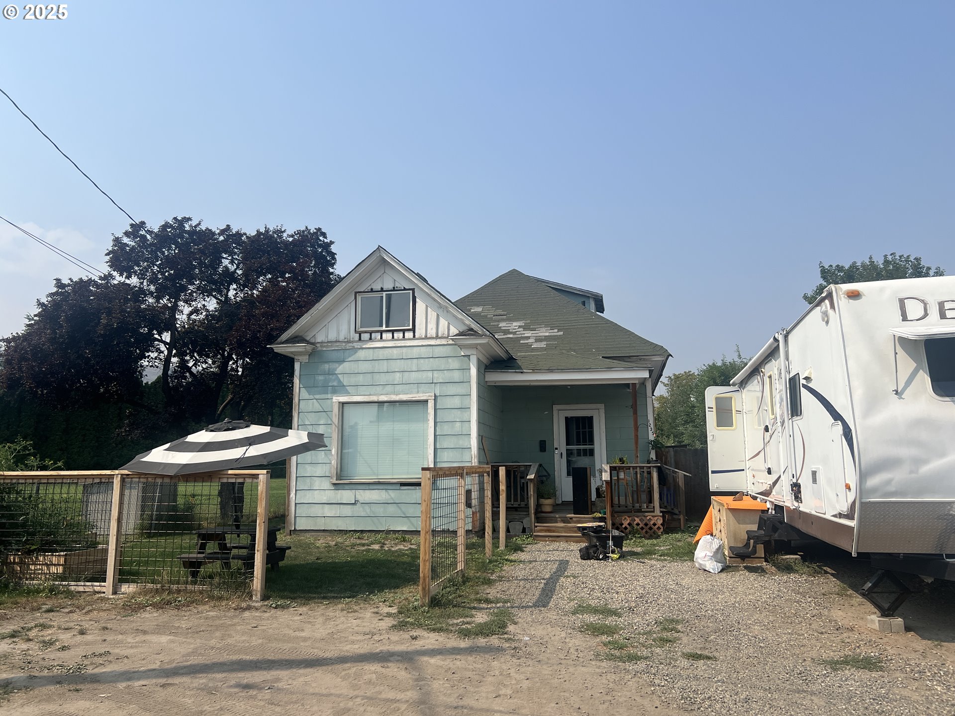 a view of a white house with a patio and a yard
