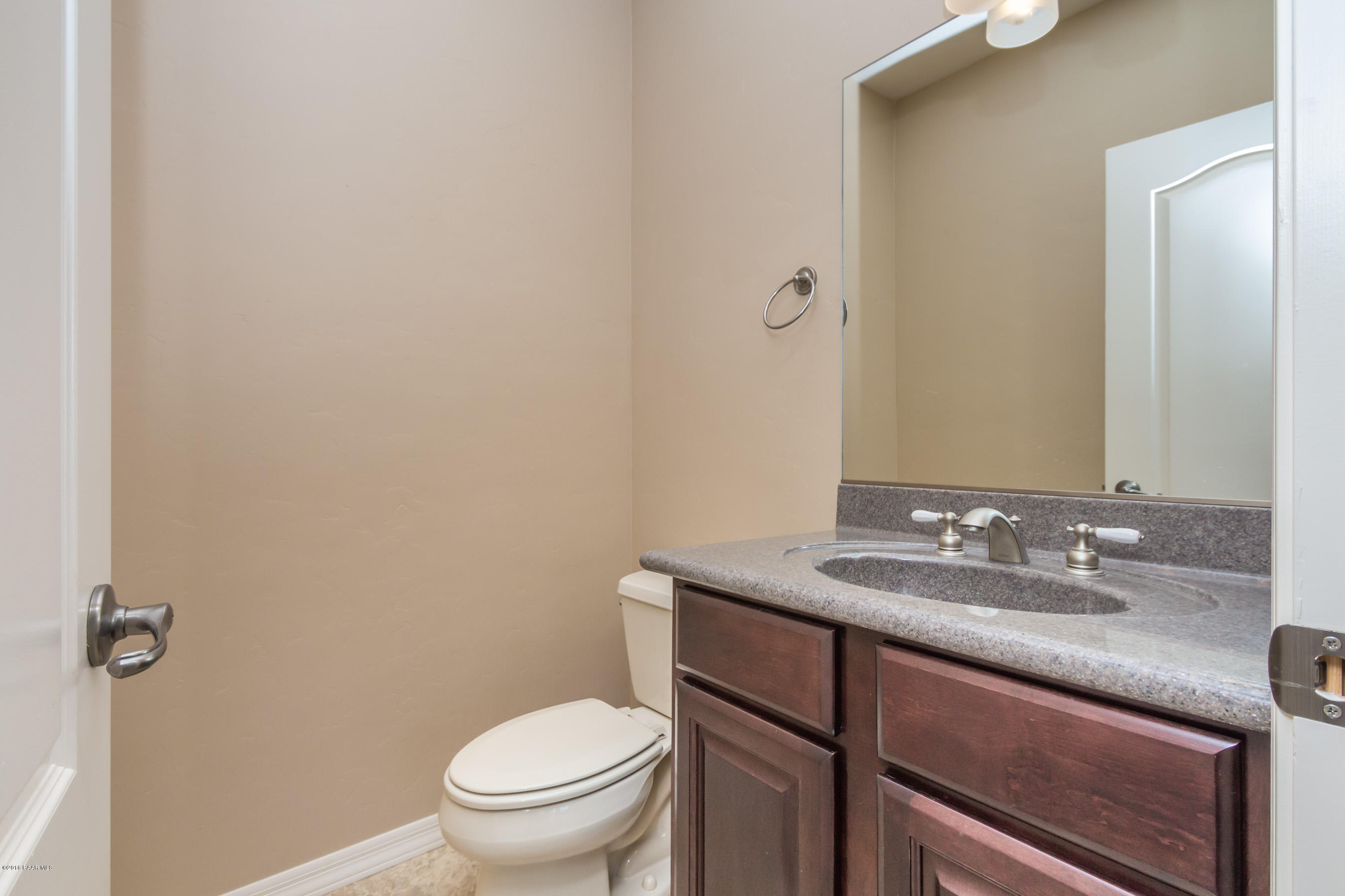 1055 Vantage Point Circle Prescott, AZ 86301 - Photo 24 of 38 a bathroom with a granite countertop sink a toilet and a mirror