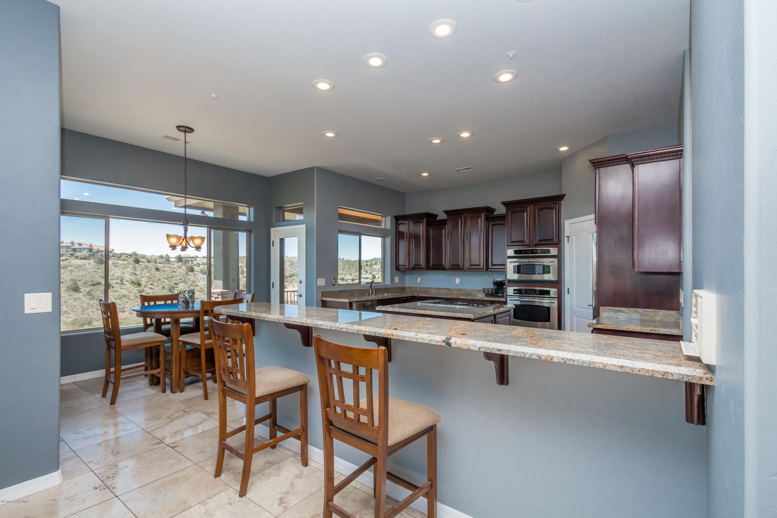 1055 Vantage Point Circle Prescott, AZ 86301 - Photo 6 of 38 a kitchen with stainless steel appliances kitchen island granite countertop a sink and cabinets