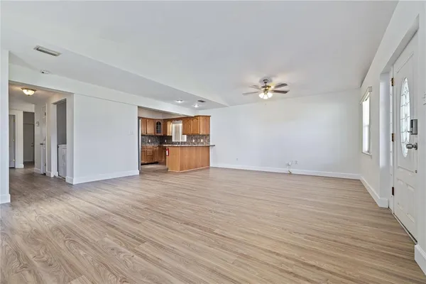 wooden floor in an empty room with a kitchen