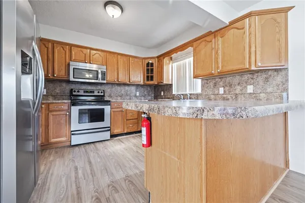 a kitchen with stainless steel appliances granite countertop a stove a sink and a microwave