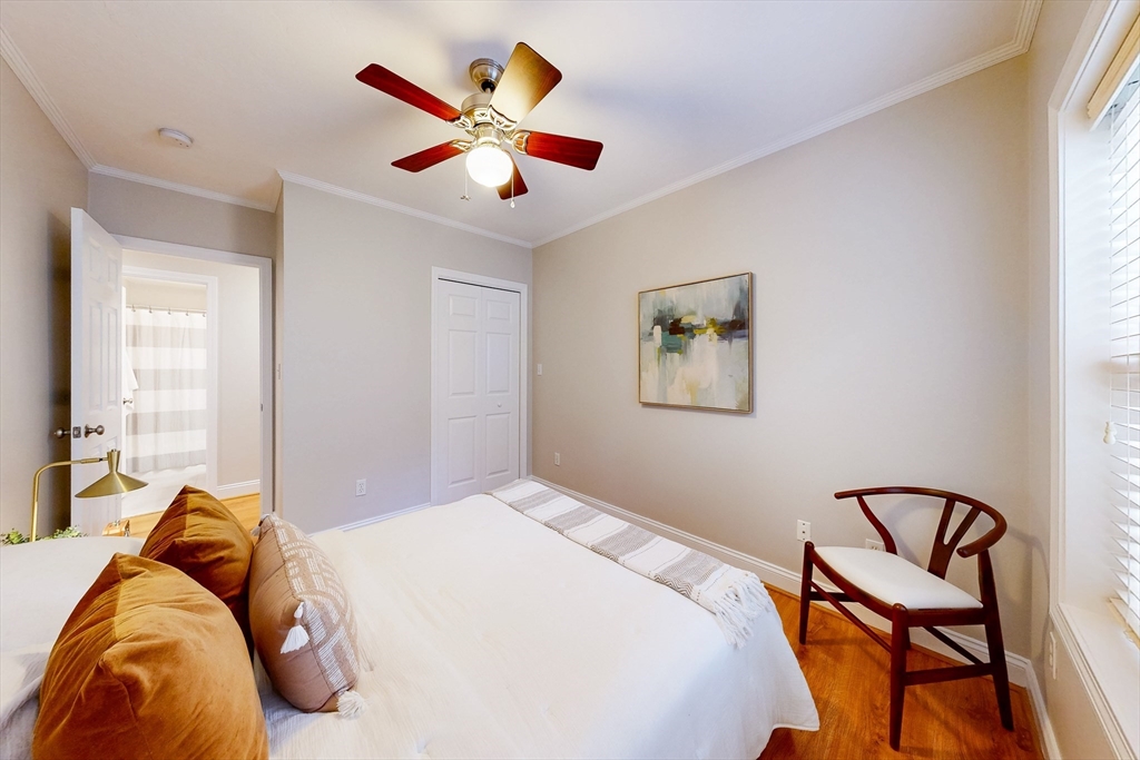 111 West 8th Street, Unit C Boston, MA 02127 - Photo 16 of 22 a bedroom with a bed and a chandelier