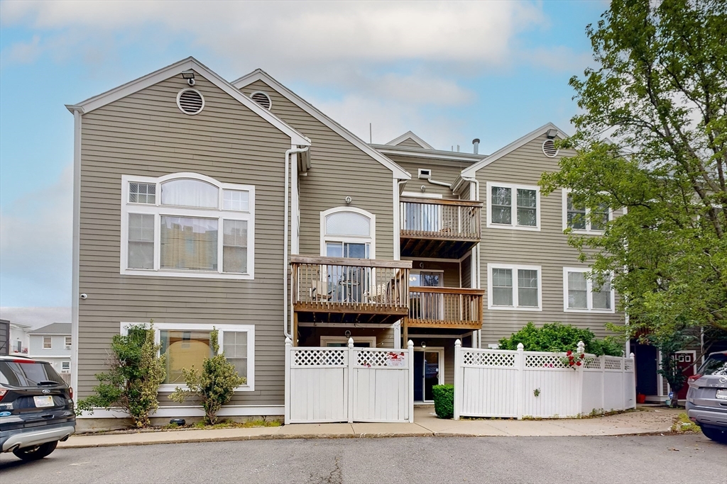 111 West 8th Street, Unit C Boston, MA 02127 - Photo 2 of 22 a front view of a house with a yard and garage