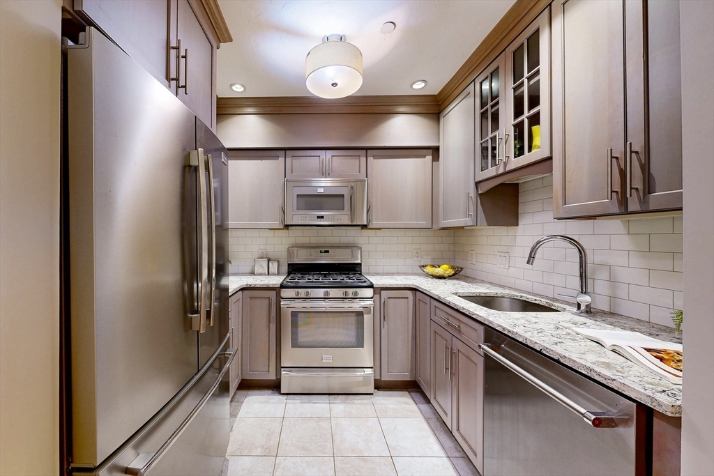 111 West 8th Street, Unit C Boston, MA 02127 - Photo 8 of 22 a kitchen with stainless steel appliances granite countertop a sink and a stove