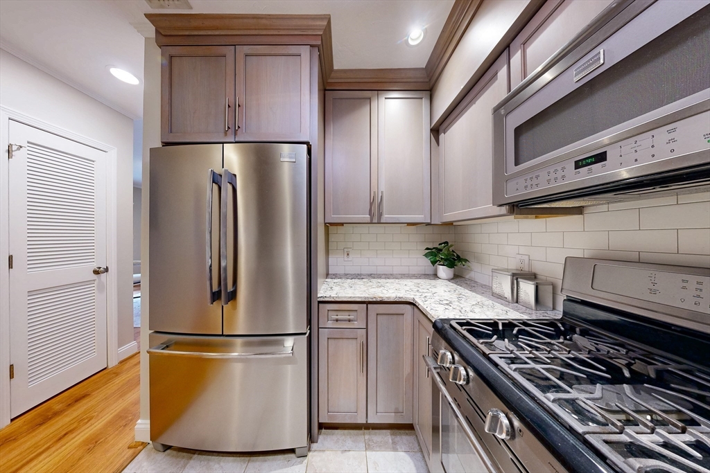111 West 8th Street, Unit C Boston, MA 02127 - Photo 9 of 22 a kitchen with a refrigerator and a stove top oven