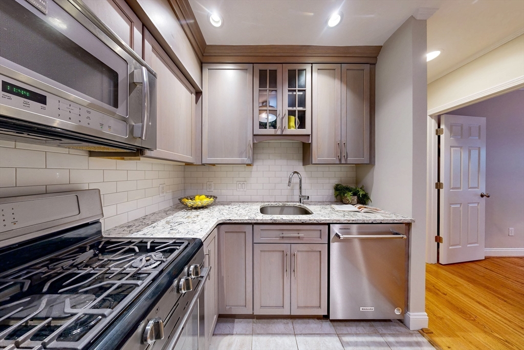 111 West 8th Street, Unit C Boston, MA 02127 - Photo 10 of 22 a kitchen with stainless steel appliances granite countertop a stove and a sink