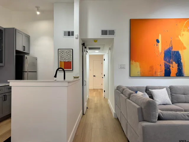 a view of a hallway with wooden floor and staircase