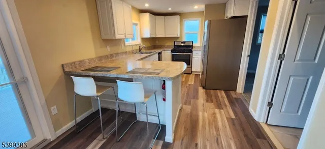 a kitchen with refrigerator a sink dishwasher and wooden cabinets
