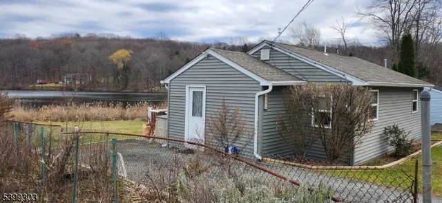 a view of house with river and trees in the background