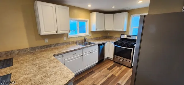 a kitchen with stainless steel appliances granite countertop a sink stove and cabinets