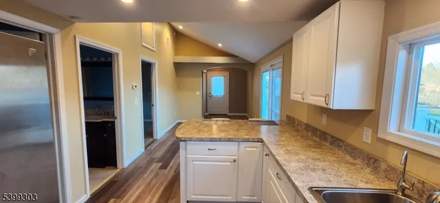 a kitchen with a granite countertop sink and refrigerator