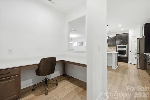 a kitchen with stainless steel appliances kitchen island hardwood floor and a sink