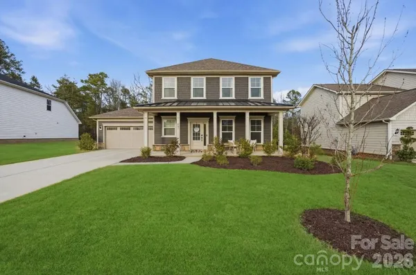 a front view of a house with yard and green space