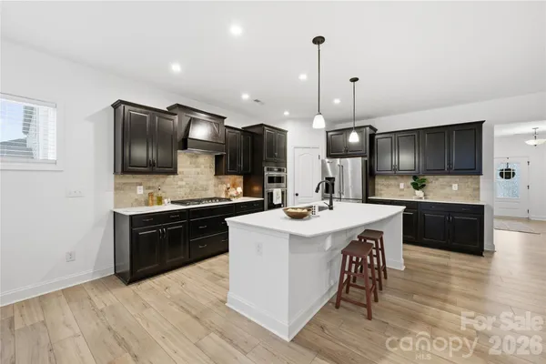 a large kitchen with a sink and stainless steel appliances