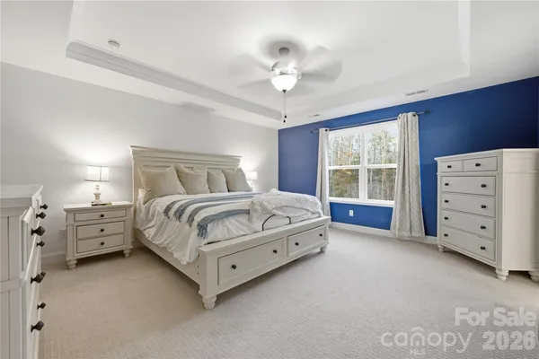 a spacious bedroom with a bed and a chandelier