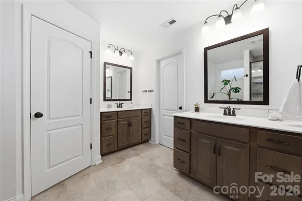 a bathroom with a double vanity sink mirror and bathtub