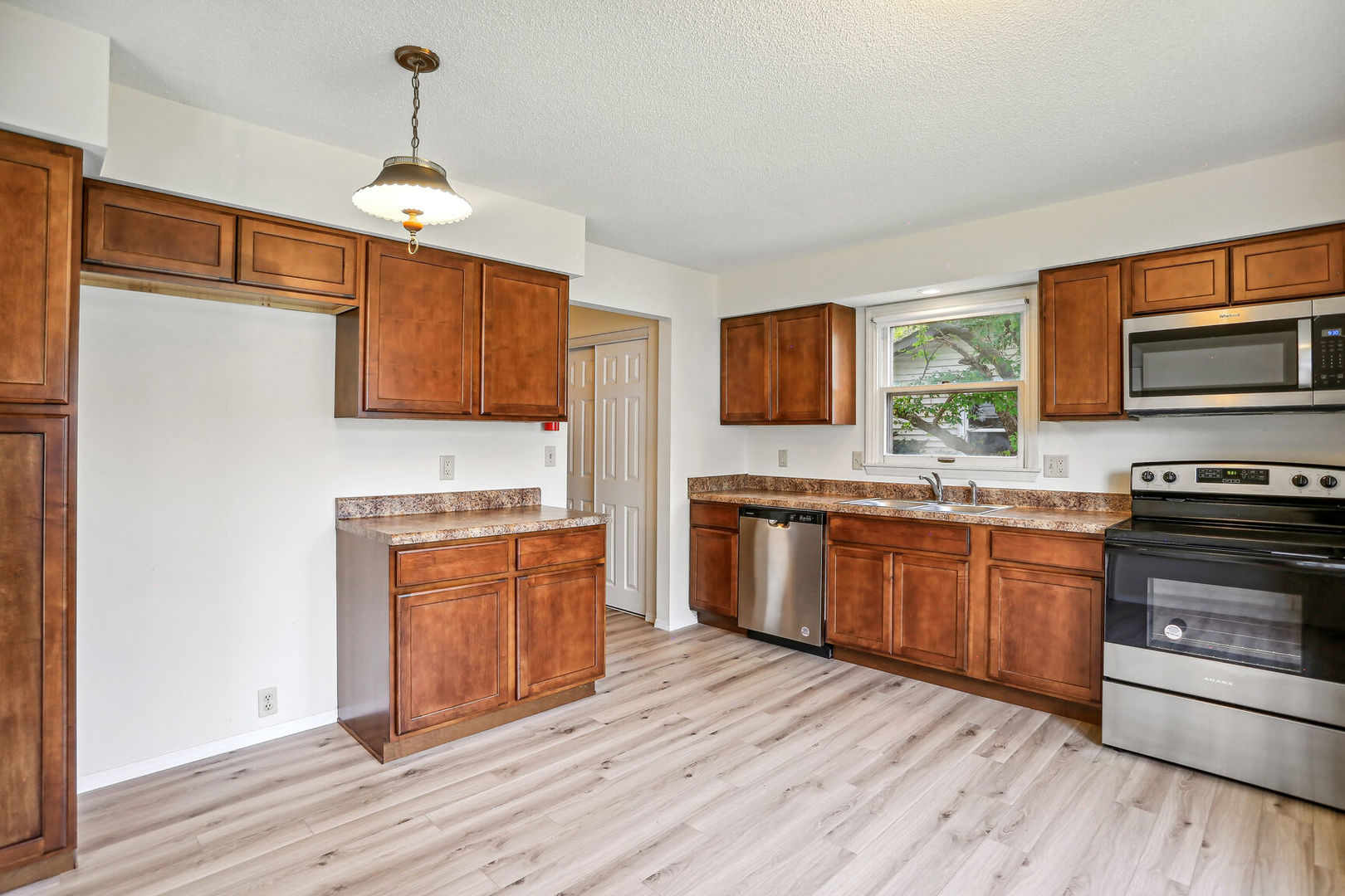 2307 Aspen Drive Champaign, IL 61821 - Photo 15 of 26 a kitchen with stainless steel appliances granite countertop a stove top oven a sink dishwasher and a microwave oven with large wooden floors