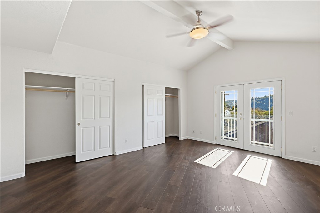 629 Poker Flat Road Copperopolis, CA 95228 - Photo 27 of 71 an empty room with wooden floor chandelier fan and windows