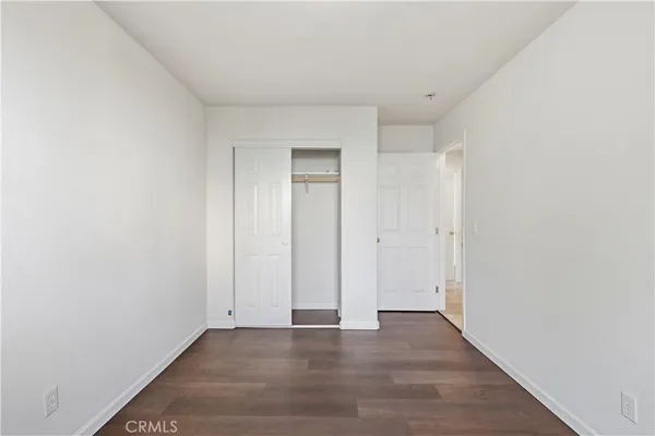 a bedroom with a bed and painting on the wall