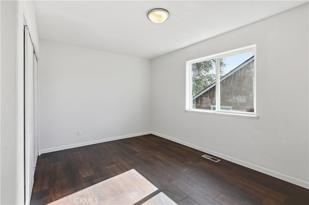 629 Poker Flat Road Copperopolis, CA 95228 - Photo 39 of 71 an empty room with wooden floor and windows