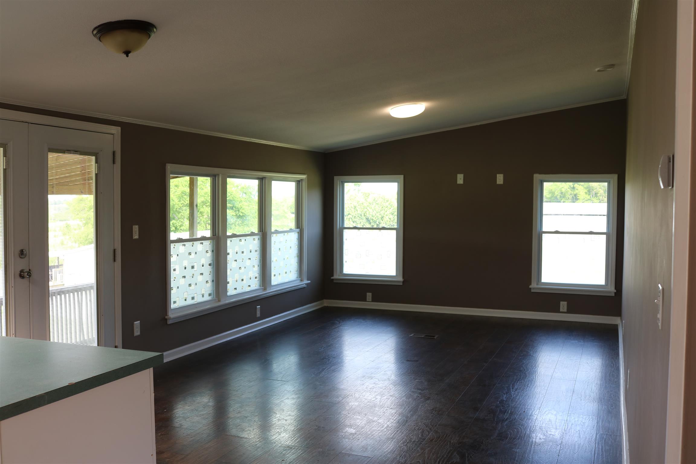 3630 Beasleys Bend Road Lebanon, TN 37087 - Photo 5 of 12 an empty room with wooden floor and windows with curtains