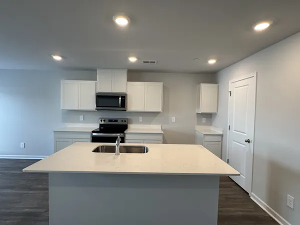 a kitchen with a sink a microwave a stove and refrigerator