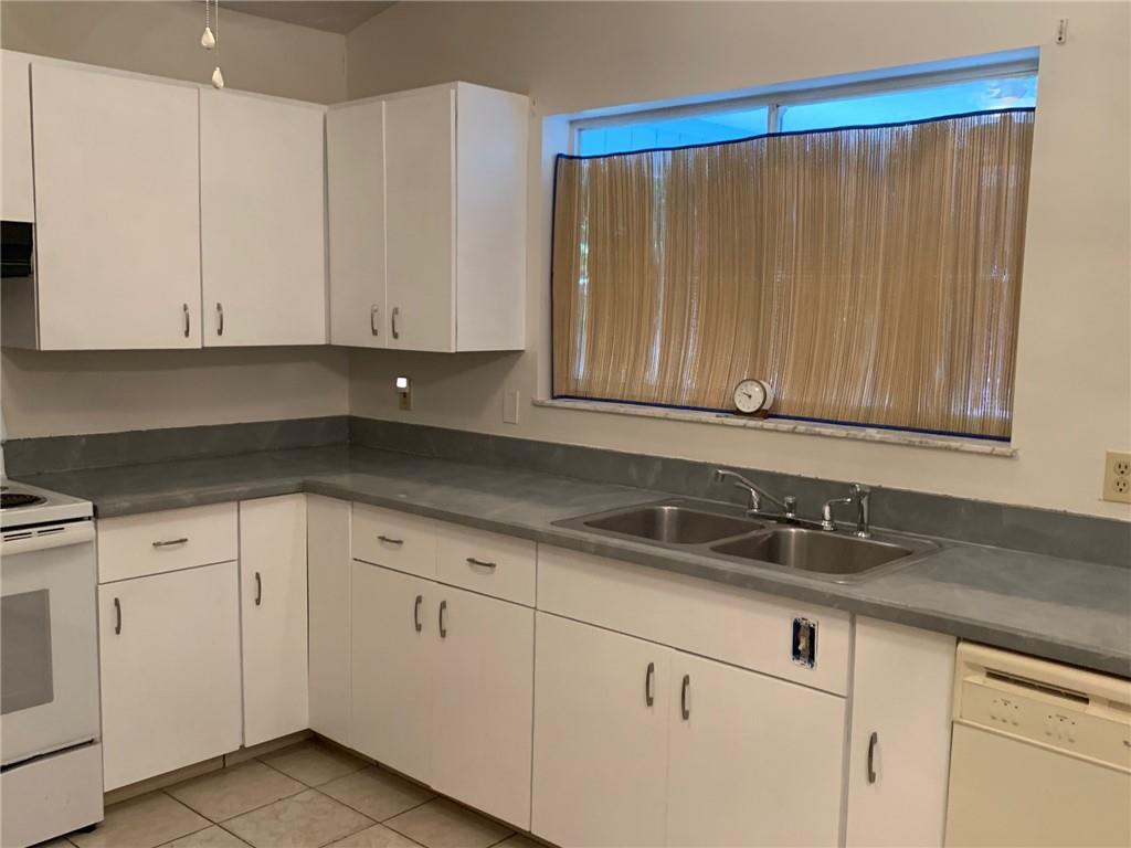 774 24th Square Vero Beach, FL 32962 - Photo 10 of 33 a kitchen with granite countertop white cabinets and sink