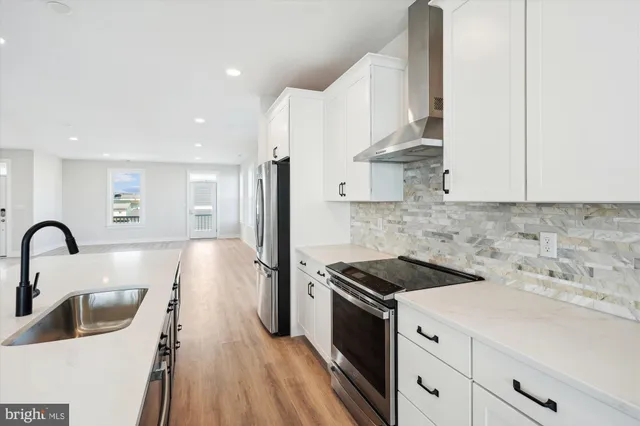 a kitchen that has a sink a stove and cabinets