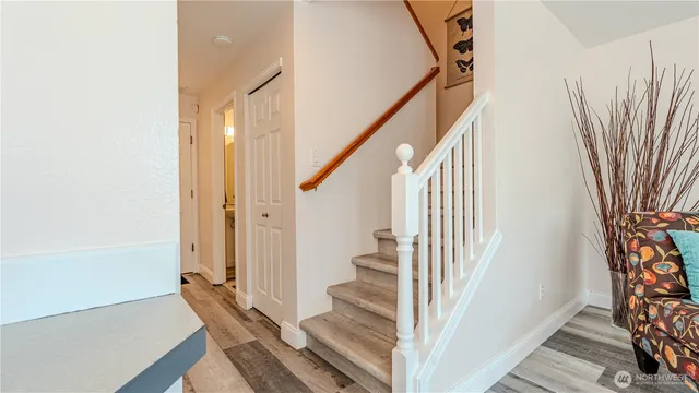 a view of a hallway with wooden floor and staircase