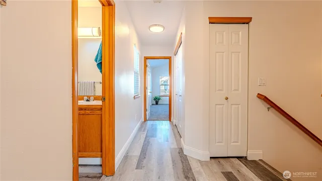 a view of a hallway with wooden floor and staircase