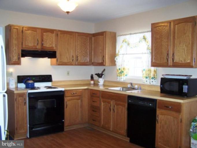 85 Walnut Creek Road Huntingtown, MD 20639 - Photo 19 of 19 a kitchen with a sink stove and cabinets