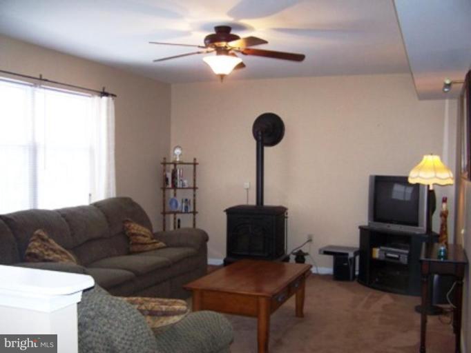 85 Walnut Creek Road Huntingtown, MD 20639 - Photo 5 of 19 a living room with furniture a ceiling fan and a window