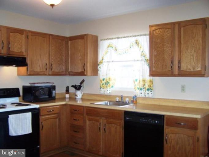 85 Walnut Creek Road Huntingtown, MD 20639 - Photo 7 of 19 a kitchen with stainless steel appliances granite countertop a sink stove and cabinets
