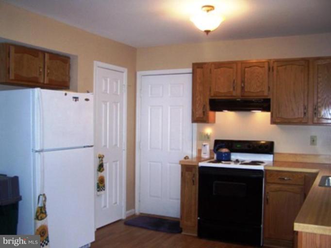 85 Walnut Creek Road Huntingtown, MD 20639 - Photo 8 of 19 a kitchen with a refrigerator and a stove top oven