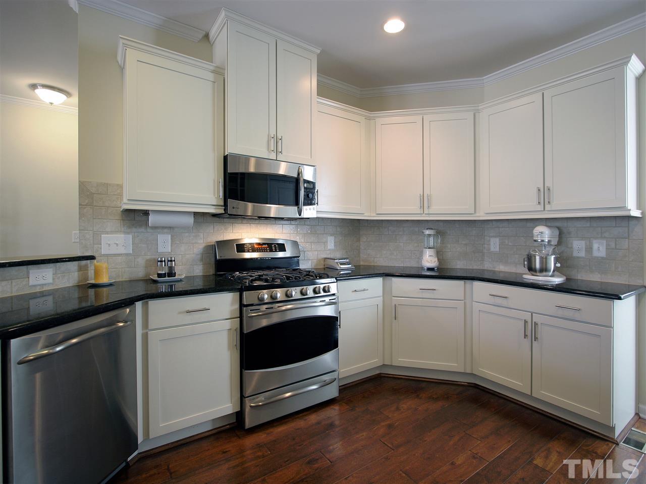 1517 Rodessa Run Raleigh, NC 27607 - Photo 8 of 25 a kitchen with stainless steel appliances granite countertop a stove a sink and white cabinets