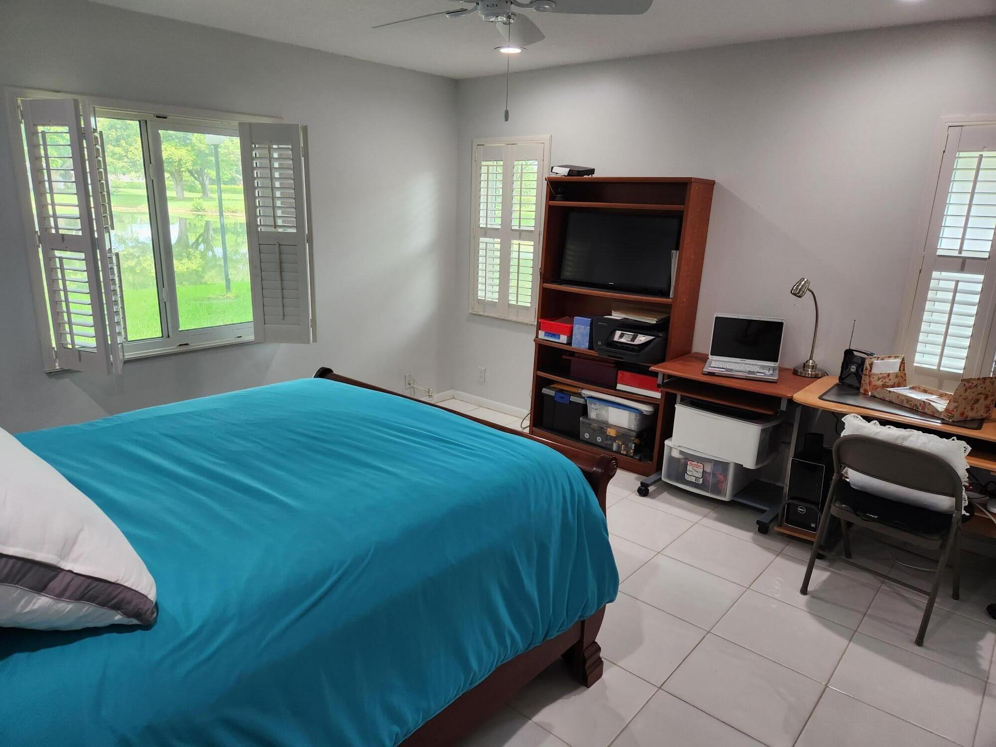 18541 Cherborg Drive, Unit D Boca Raton, FL 33496 - Photo 11 of 36 a bedroom with a bed and a flat screen tv