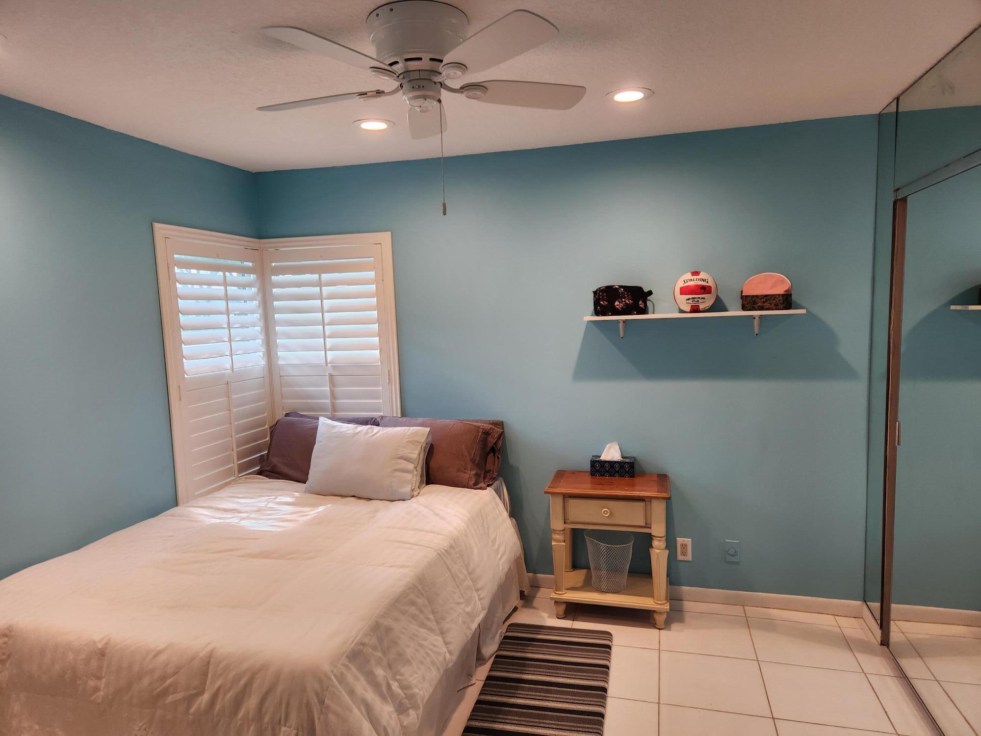 18541 Cherborg Drive, Unit D Boca Raton, FL 33496 - Photo 14 of 36 a bedroom with a bed and a chandelier