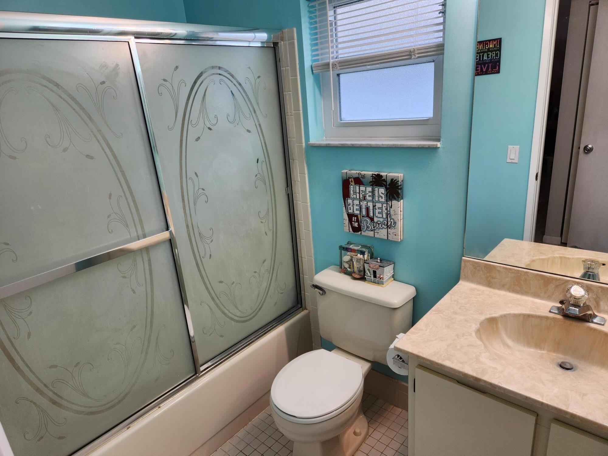 18541 Cherborg Drive, Unit D Boca Raton, FL 33496 - Photo 15 of 36 a white toilet sitting next to a bathroom sink and vanity