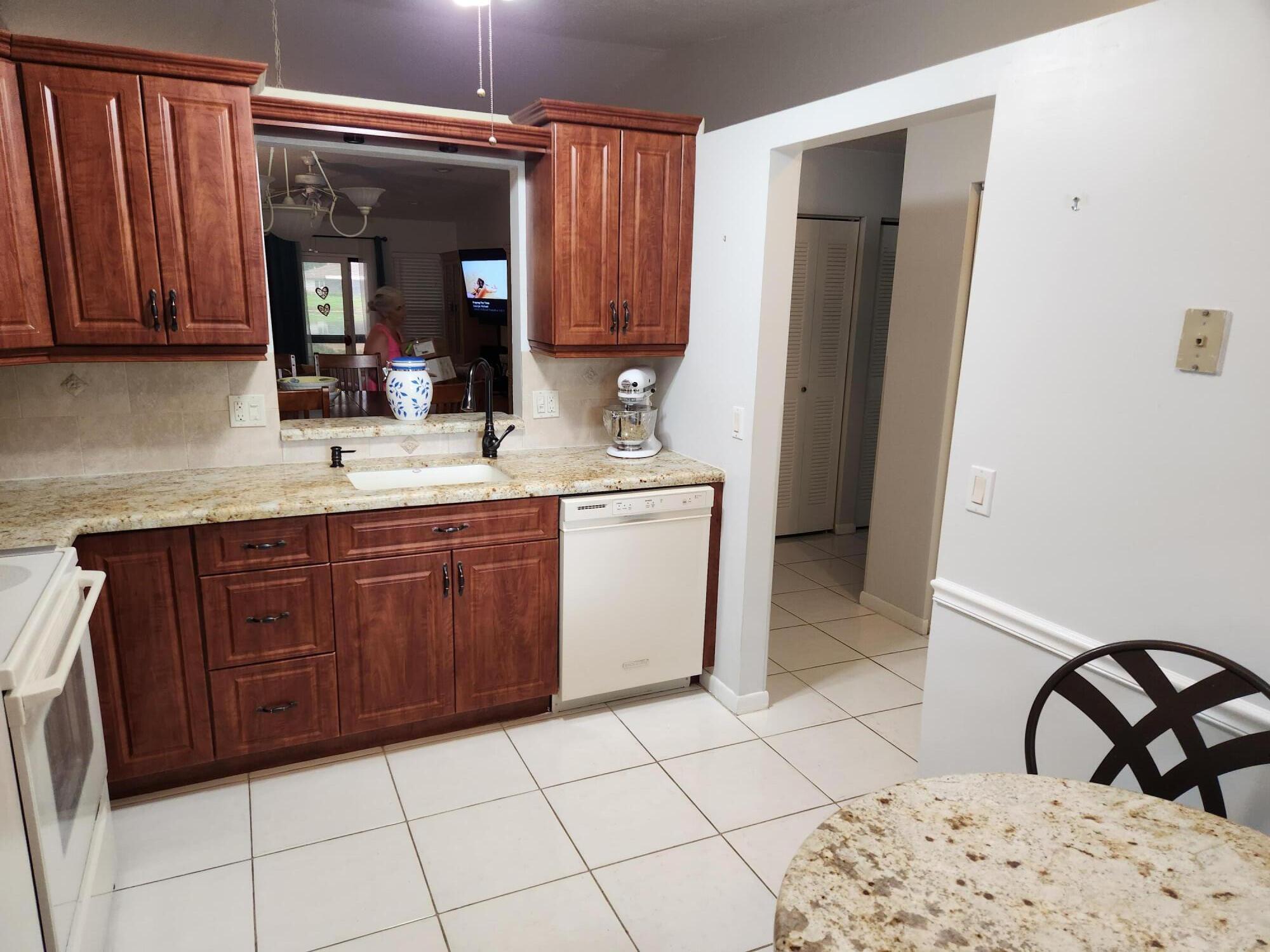18541 Cherborg Drive, Unit D Boca Raton, FL 33496 - Photo 8 of 36 a kitchen with a sink a stove and wooden cabinets
