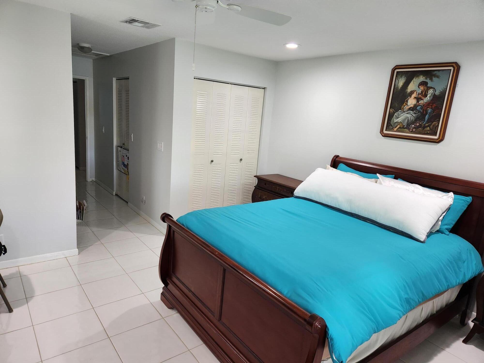 18541 Cherborg Drive, Unit D Boca Raton, FL 33496 - Photo 9 of 36 a bedroom with a bed and a painting on the wall