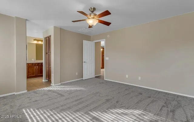 an empty room with closet and fan