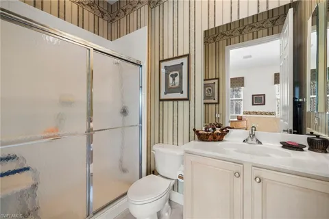a bathroom with a sink a toilet a mirror and shower