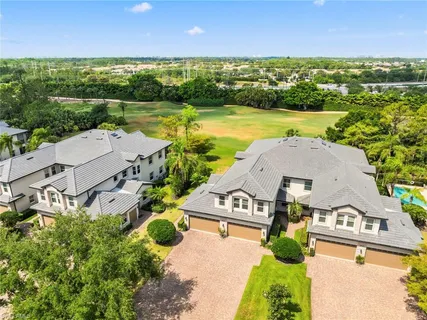an aerial view of residential houses with outdoor space and ocean view
